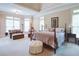 Spacious main bedroom featuring a luxurious bed, a seating area, and ample natural light at 8440 Woodland Brooke Trl, Cumming, GA 30028