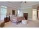 Main bedroom with a plush bed, tray ceiling, and ample natural light creating a serene retreat at 8440 Woodland Brooke Trl, Cumming, GA 30028