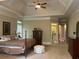 Spacious main bedroom showcasing trey ceilings, neutral walls, a ceiling fan, and large windows at 8440 Woodland Brooke Trl, Cumming, GA 30028