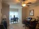 Home office with multiple desks, chairs, and a ceiling fan at 8440 Woodland Brooke Trl, Cumming, GA 30028