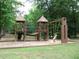 Well maintained wooden playground with swings and climbing structures for fun at 8440 Woodland Brooke Trl, Cumming, GA 30028