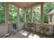 Screened-in porch with decorative chairs, tile flooring, and wooded backyard views at 8440 Woodland Brooke Trl, Cumming, GA 30028