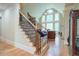 Elegant staircase with wood and iron detailing leading to the upper level, filling the home with light at 8440 Woodland Brooke Trl, Cumming, GA 30028
