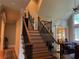 Staircase featuring wood treads, iron railings, and natural lighting from adjacent windows at 8440 Woodland Brooke Trl, Cumming, GA 30028