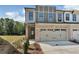 Charming townhome exterior with a brick facade, two-car garage, and manicured lawn on a sunny day at 579 Collections Dr, Lawrenceville, GA 30043