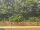 A backyard featuring a wooden fence and abundant trees at 684 Sundial Ln, Mableton, GA 30126