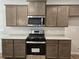 Well-equipped kitchen with stainless steel oven, microwave, granite countertops and wood cabinets at 684 Sundial Ln, Mableton, GA 30126