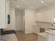 Bright kitchen featuring white cabinetry, granite countertops, stainless steel appliances, and hardwood floors at 684 Sundial Ln, Mableton, GA 30126