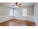 Bedroom with ceiling fan, hardwood floors, wainscoting, and two bright windows at 1810 Oakmont Nw Dr, Atlanta, GA 30314