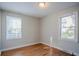 Bedroom featuring hardwood floors with two large windows for natural light at 1810 Oakmont Nw Dr, Atlanta, GA 30314