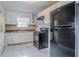 Compact kitchen with white cabinets, black appliances, and tiled backsplash at 1810 Oakmont Nw Dr, Atlanta, GA 30314
