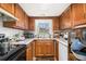 Compact kitchen with wooden cabinets, stainless steel appliances, and granite countertops at 4526 Golf Vista Cir, Decatur, GA 30035