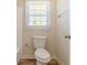 Compact bathroom featuring a toilet, and window for natural light at 5498 Balmoral Dr, Douglasville, GA 30135