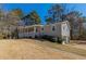 View of ranch style home with a side entry garage, covered front porch, and mature landscaping at 5498 Balmoral Dr, Douglasville, GA 30135