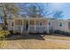 Charming single-story home featuring a covered front porch, a well-manicured lawn, and professional landscaping at 5498 Balmoral Dr, Douglasville, GA 30135