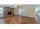 Open-concept living room seamlessly connects to the kitchen, featuring hardwood floors and a brick fireplace at 5498 Balmoral Dr, Douglasville, GA 30135