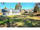 Spacious backyard with lawn, fence, and exterior view of houses under a clear blue sky at 682 New England Way, Lawrenceville, GA 30046