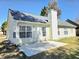Rear exterior view of house featuring a patio, ample windows, chimney, and security door at 682 New England Way, Lawrenceville, GA 30046