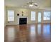 Spacious living room featuring a fireplace, multiple windows, and glossy hardwood floors at 682 New England Way, Lawrenceville, GA 30046