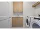 Well-lit laundry room with wooden cabinets, white countertop and modern Whirlpool washer and dryer at 2425 Peachtree Ne Rd # 903, Atlanta, GA 30305
