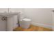 Modern powder room featuring hardwood floors and a pedestal sink and toilet at 2425 Peachtree Ne Rd # 903, Atlanta, GA 30305