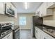 Well-lit kitchen with white cabinets, stainless steel appliances, and black granite countertops at 1662 Flintwood Se Dr, Atlanta, GA 30316