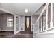 Welcoming front entrance with wooden door, white staircase, and ample natural light at 4332 N Hickory Ln, Douglasville, GA 30134