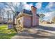Rear view of brick house with a chimney, patio, and driveway at 4332 N Hickory Ln, Douglasville, GA 30134