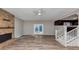 Open-concept living room with fireplace, wood floors, stairs, and adjacent kitchen area at 4332 N Hickory Ln, Douglasville, GA 30134