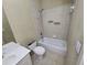A compact bathroom featuring a built-in bathtub with tiled walls and a standard toilet at 4520 Mossey Dr, Lithonia, GA 30038