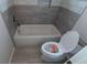 Compact bathroom featuring gray tile and standard tub and toilet at 4520 Mossey Dr, Lithonia, GA 30038