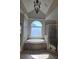 Bathroom showcases a soaking tub beneath an arched window, complemented by a glass-enclosed shower at 4520 Mossey Dr, Lithonia, GA 30038