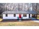 Charming single-story home with a bright red front door and covered parking at 4776 Ballew Dr, Powder Springs, GA 30127