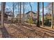 View of backyard featuring mature trees, lush green lawn, wooden fence and spacious deck at 5956 Henley Dr, Powder Springs, GA 30127