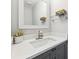 Modern bathroom featuring granite counters, gray cabinets, a decorative mirror, and a faux plant at 5956 Henley Dr, Powder Springs, GA 30127