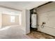 Basement with carpeted area and utility closet featuring a water heater and shelving at 6138 Raleigh Oaks Ct, Lithonia, GA 30058