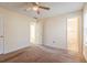 Bright carpeted bedroom featuring a ceiling fan and multiple doorways, plus neutral paint throughout at 6138 Raleigh Oaks Ct, Lithonia, GA 30058