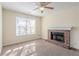 Living room featuring a brick fireplace, carpet flooring, and a large window for natural light at 6138 Raleigh Oaks Ct, Lithonia, GA 30058
