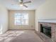 Living room with a brick fireplace, carpet flooring, and a large window for natural light at 6138 Raleigh Oaks Ct, Lithonia, GA 30058