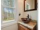 Powder room with a bronze vessel sink and granite countertop near a window view at 616 Redwood Ln, Canton, GA 30114