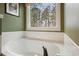 Modern bathroom soaking tub and large window bringing natural light into the home at 616 Redwood Ln, Canton, GA 30114