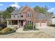 Charming brick home featuring a cozy front porch, an American flag, and an attached garage at 616 Redwood Ln, Canton, GA 30114