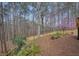 Home's exterior showcases a spacious deck and backyard with a privacy fence, set against a tranquil backdrop of mature trees at 616 Redwood Ln, Canton, GA 30114