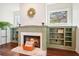 Close-up of a charming brick fireplace with green built-in shelves, hardwood floors, and natural light at 616 Redwood Ln, Canton, GA 30114