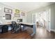 Bright home office featuring hardwood floors, a large desk, and an open doorway to the staircase at 616 Redwood Ln, Canton, GA 30114