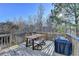 Outdoor wooden back deck with table and chairs, along with a covered grill for outdoor cooking at 6574 Barker Station Walk, Sugar Hill, GA 30518