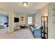 Inviting bonus room featuring carpet flooring, a blue sofa, television, and small table with chairs at 6574 Barker Station Walk, Sugar Hill, GA 30518