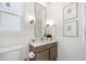 Stylish half-bathroom with a sleek vanity, gold fixtures, and decorative wall art at 929 Keystone Dr, Woodstock, GA 30188