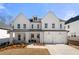 Charming two-story white home with a covered porch, well-manicured lawn and a two-car garage at 929 Keystone Dr, Woodstock, GA 30188