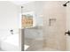 Bathroom featuring large glass shower with built-in bench; a bathtub is situated beneath a sunny window at 1847 Davis Mill N Rd, Dallas, GA 30157